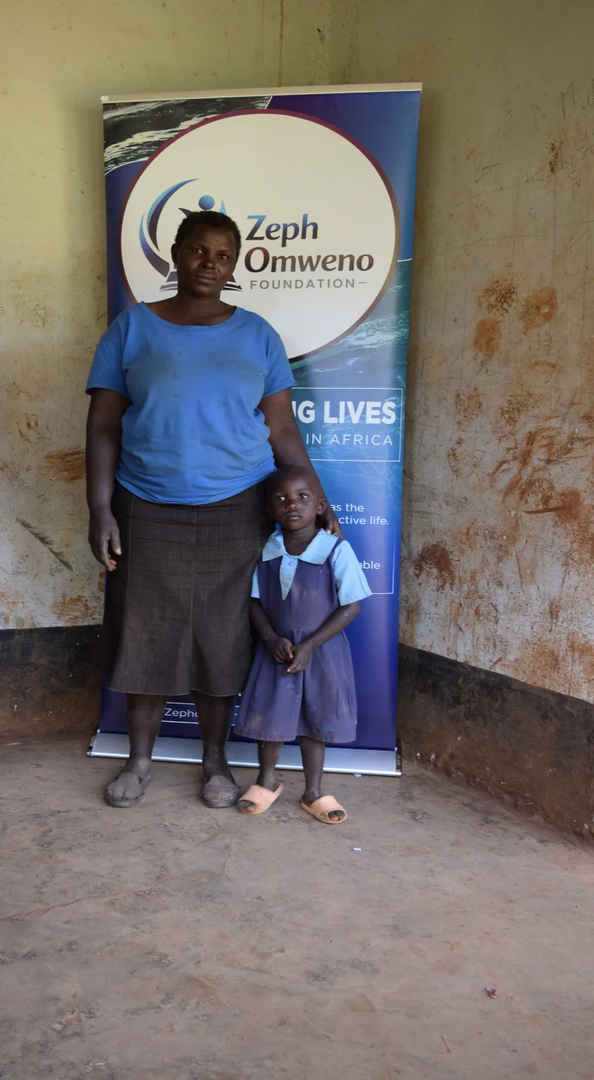 A parent and her daughter in a new school uniform